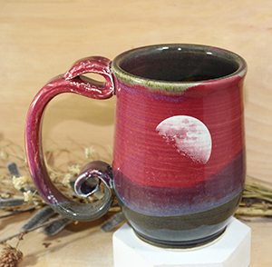 A ceramic mug with a moon engraved into it